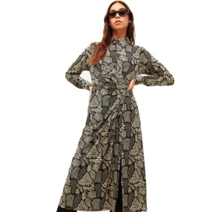 Φόρεμα μακρύ με γιακά λαπιέλ και κουμπιά το μπροστινό μέρος και σούρα κάτω αριστερά στην μέση σε λευκό χρώμα και με μαύρα μίνιμαλ σχέδια της εταιρίας Xantik